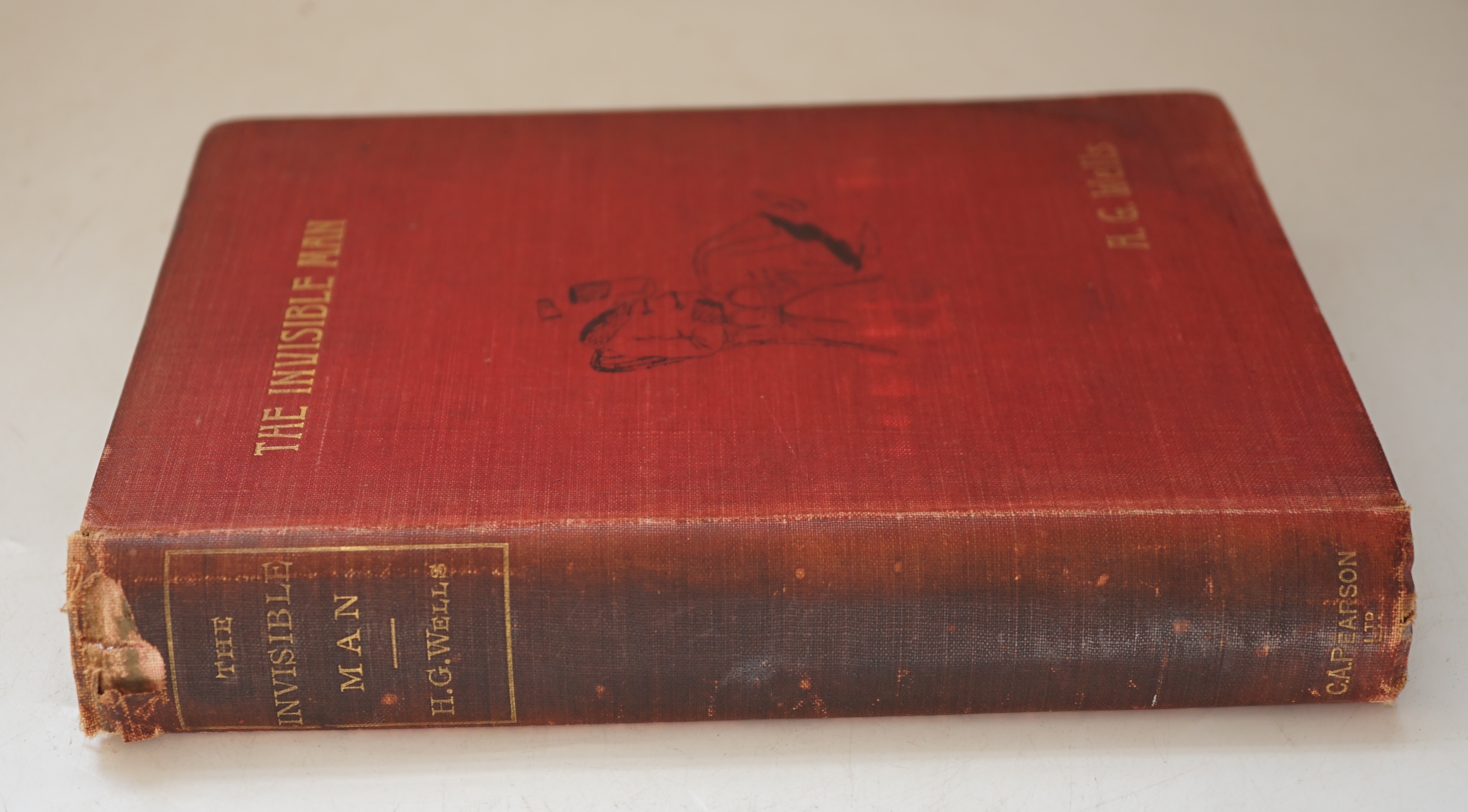 Wells, H. G. (1866-1946). The Invisible Man. A Grotesque Romance, 8vo, half title, title printed in orange and black, 2-pages of publisher's advertisements at the end, original red pictorial cloth lettered in gilt, light